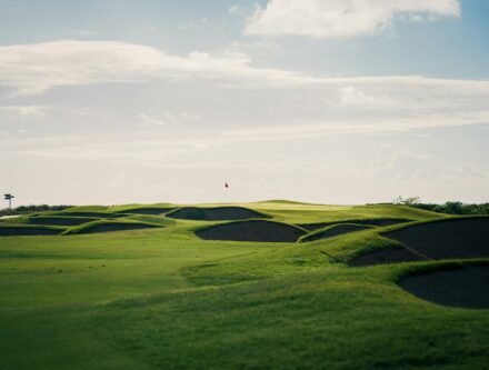 Undulating green golf course with several sand bunkers, a setting for a corporate retreat
