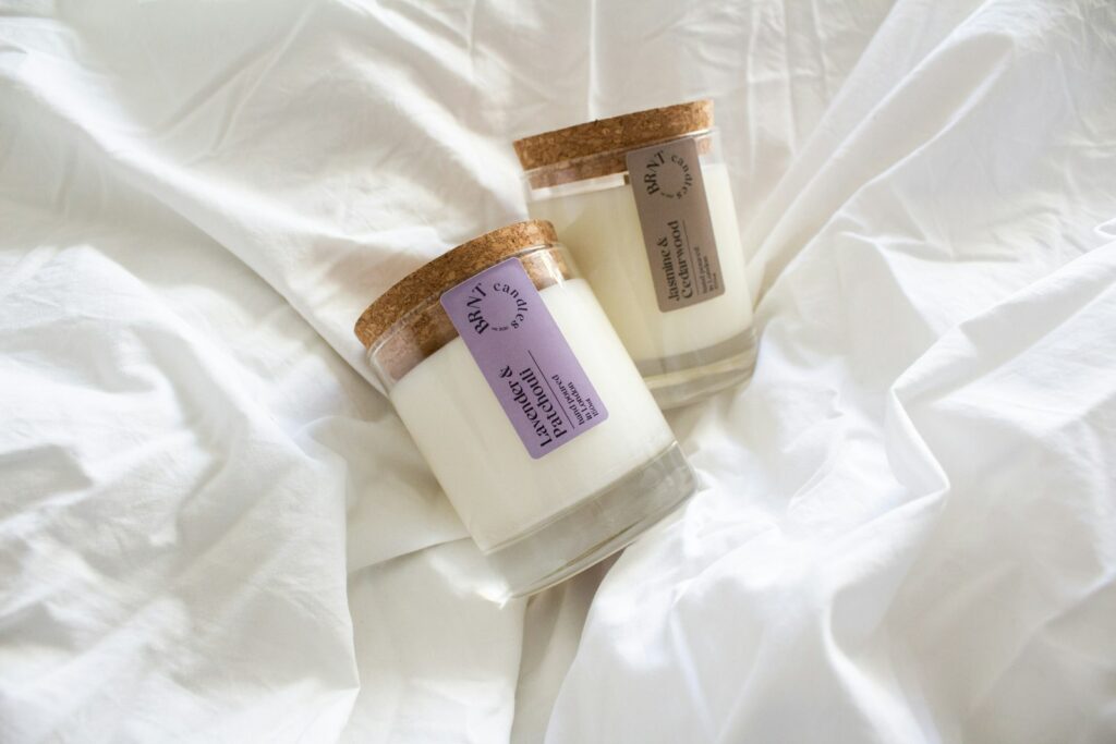 Natural candles resting on a white cotton sheet, a simple way to scent a bedroom