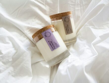 Natural candles resting on a white cotton sheet, a simple way to scent a bedroom