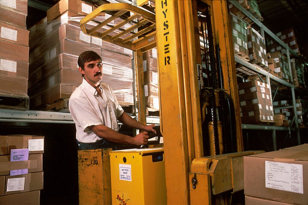 Man driving a yellow forklift inside a warehouse