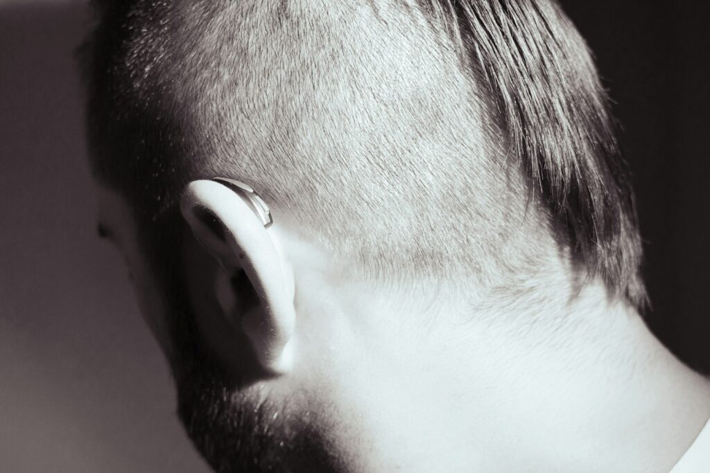 Close-up black and white shot of a person's ear with hearing aids