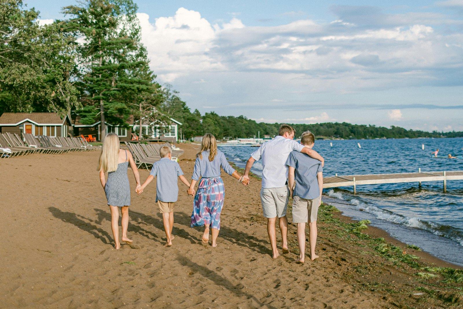 Family walking along the beach holding hands, evoking a holiday together