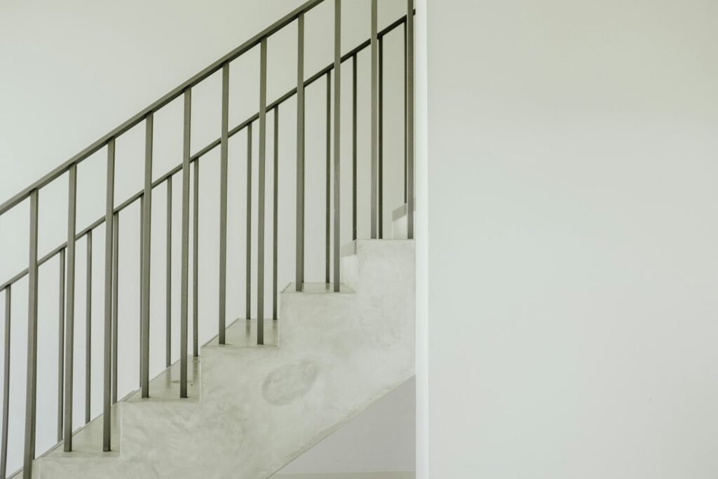 Staircase with a grey steel handrail running alongside the steps