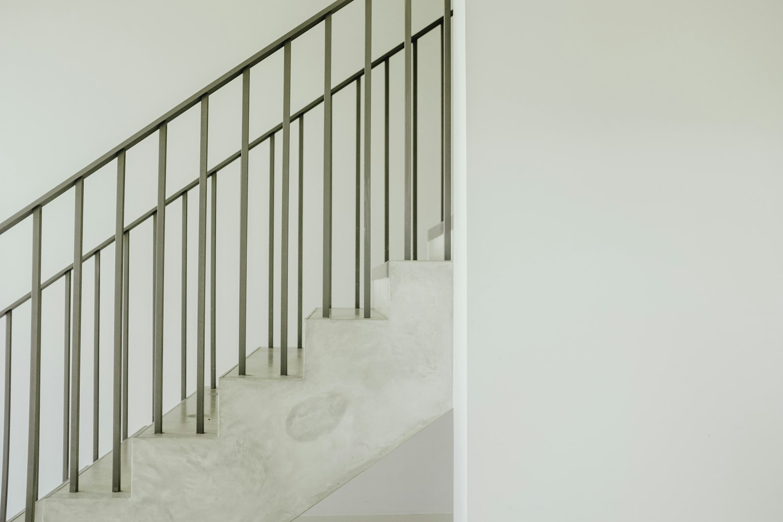 Staircase with a grey steel handrail running alongside the steps