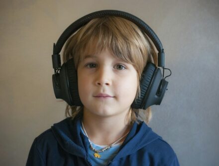 Young boy wearing professional headphones over his ears, relating to children's hearing