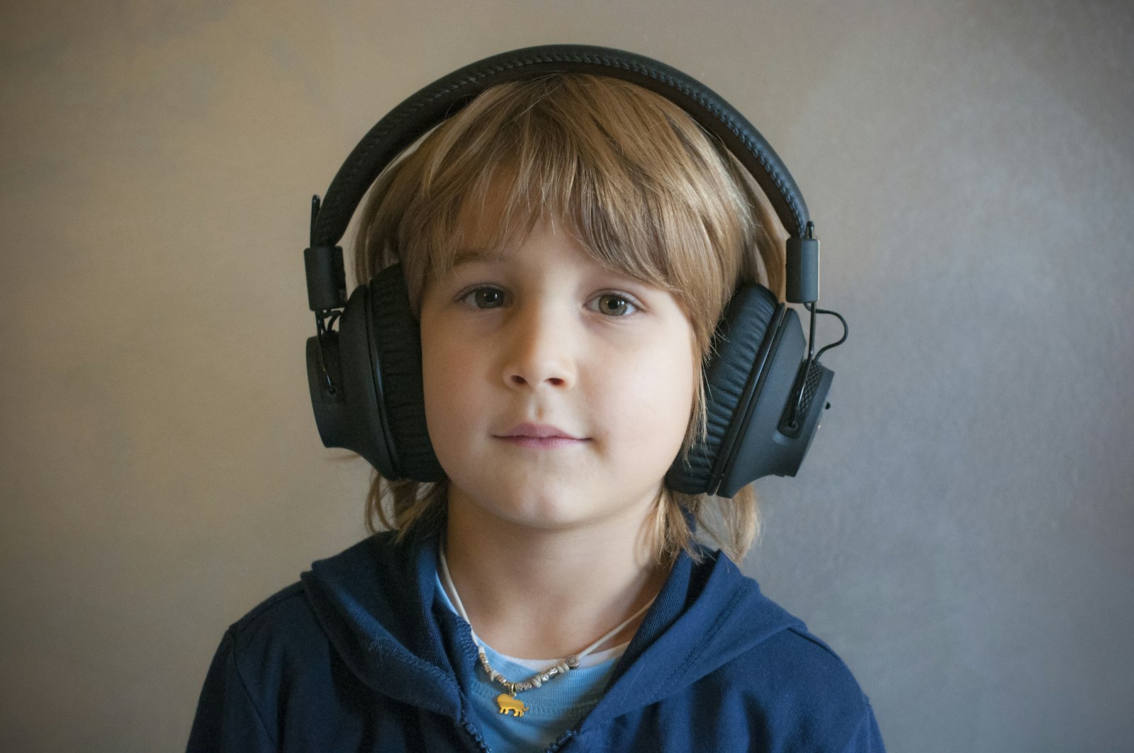 Young boy wearing professional headphones over his ears, relating to children's hearing