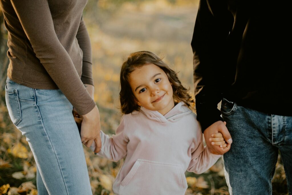 A child holding hands with people around them, suggesting care and support
