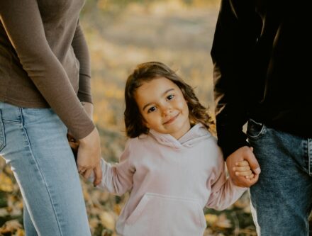 A child holding hands with people around them, suggesting care and support