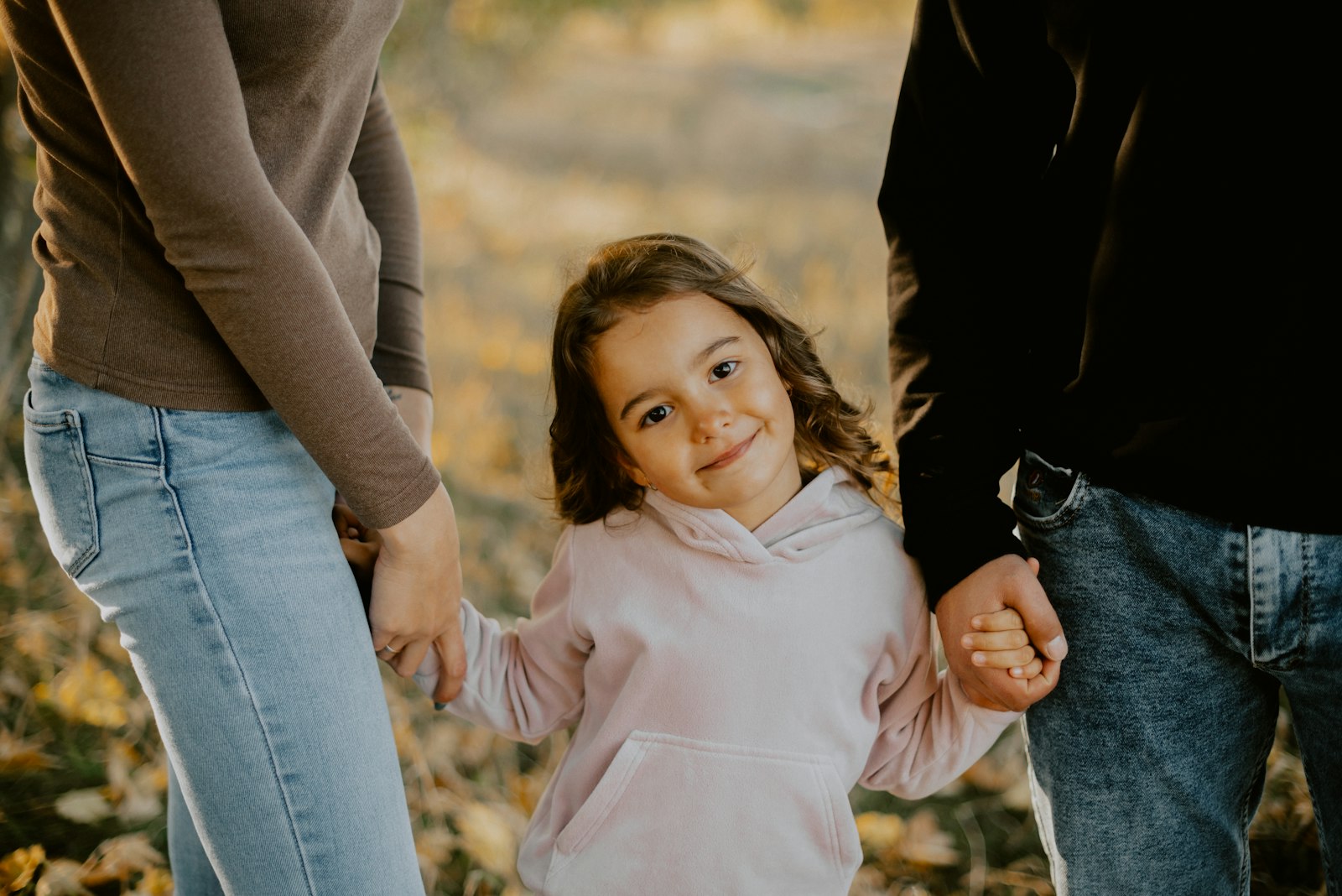 A child holding hands with people around them, suggesting care and support