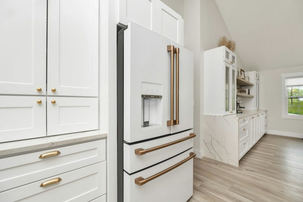 Kitchen with white cabinets and gold handles, where soft-close hinges would keep doors quiet