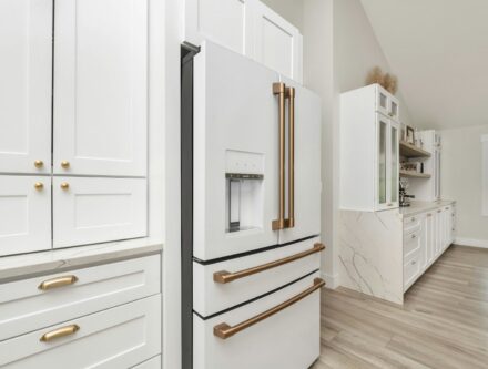 Kitchen with white cabinets and gold handles, where soft-close hinges would keep doors quiet