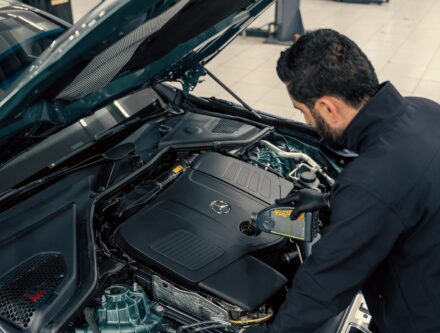 Mechanic inspecting a car engine under an open bonnet