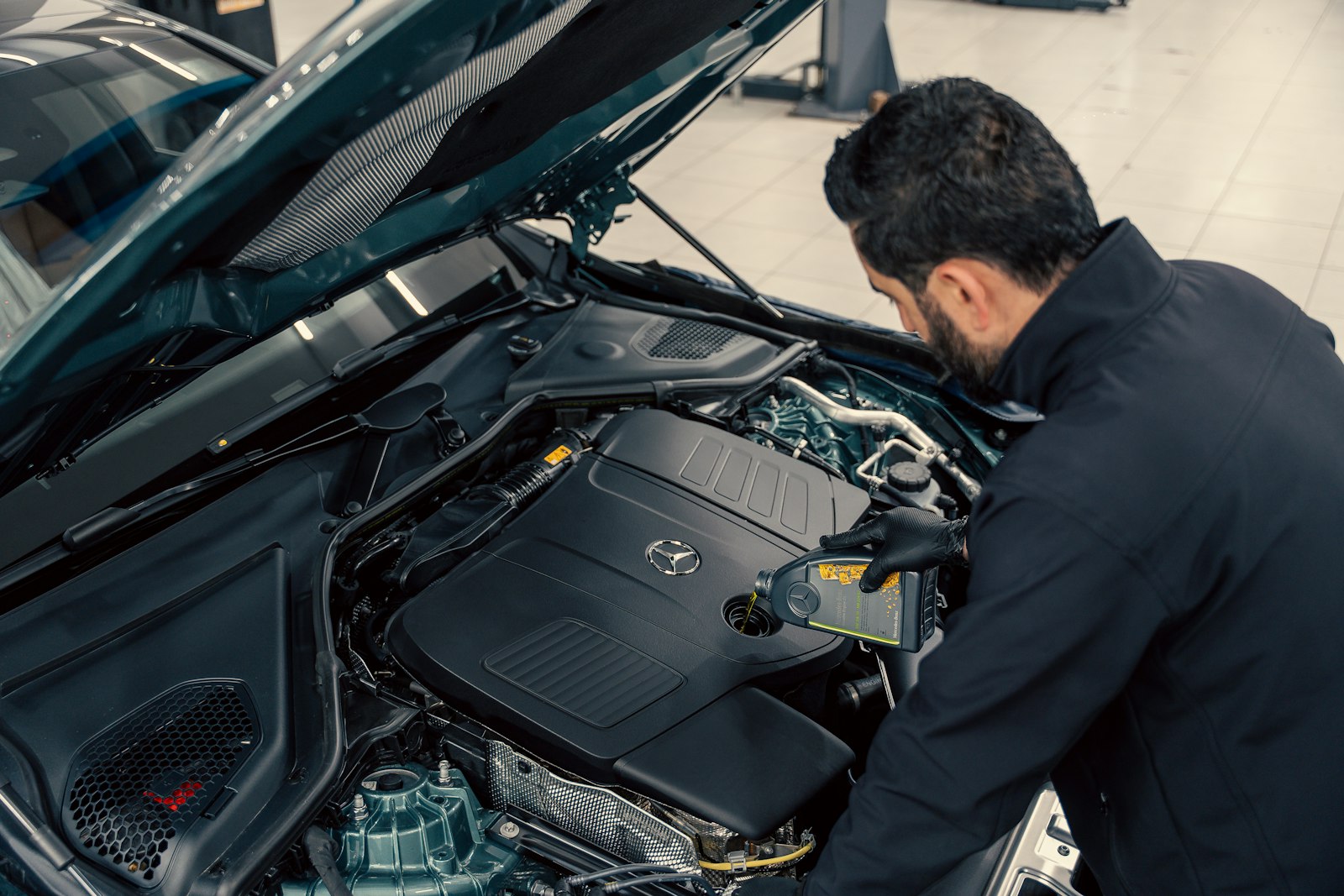 Mechanic inspecting a car engine under an open bonnet