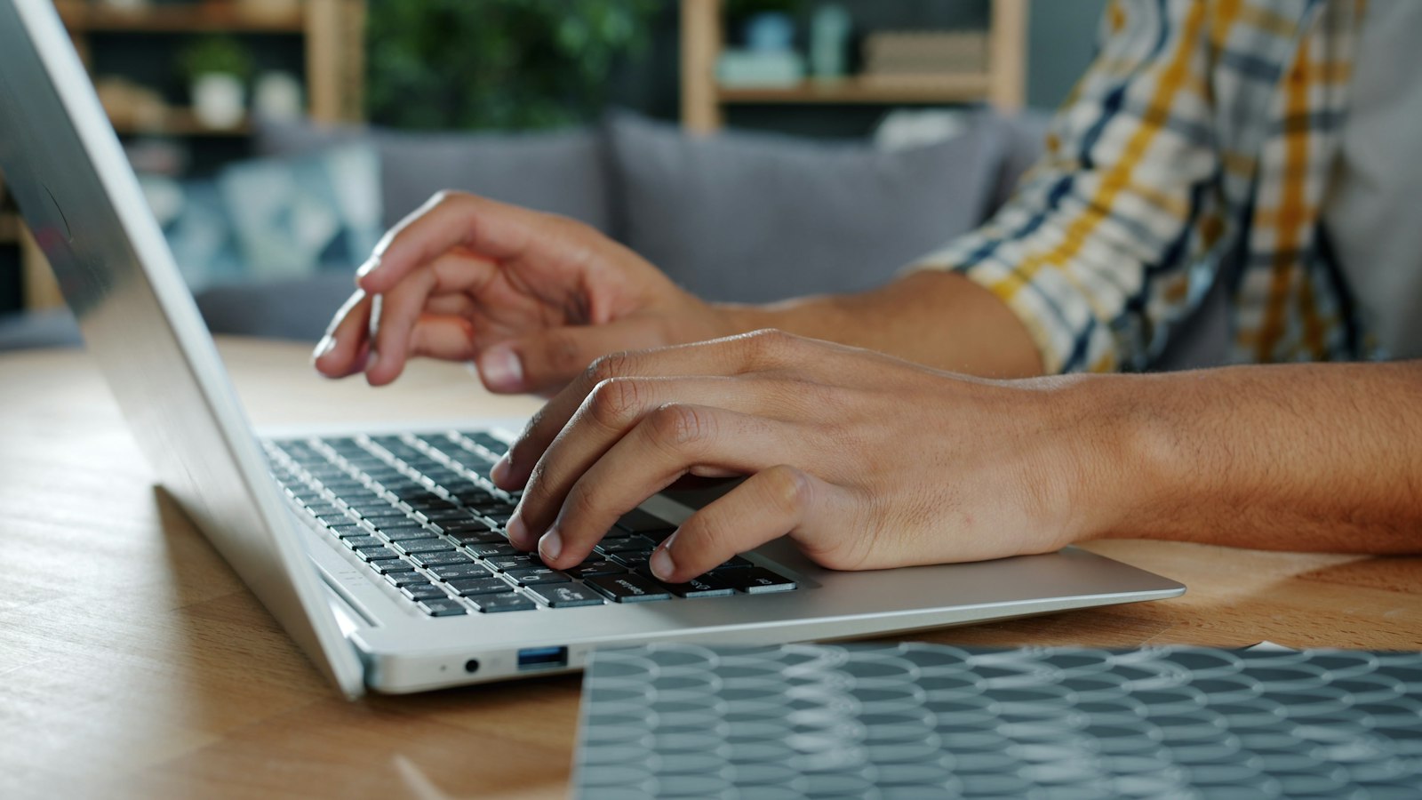 Person typing on a laptop at a desk, where one careless click can cause harm
