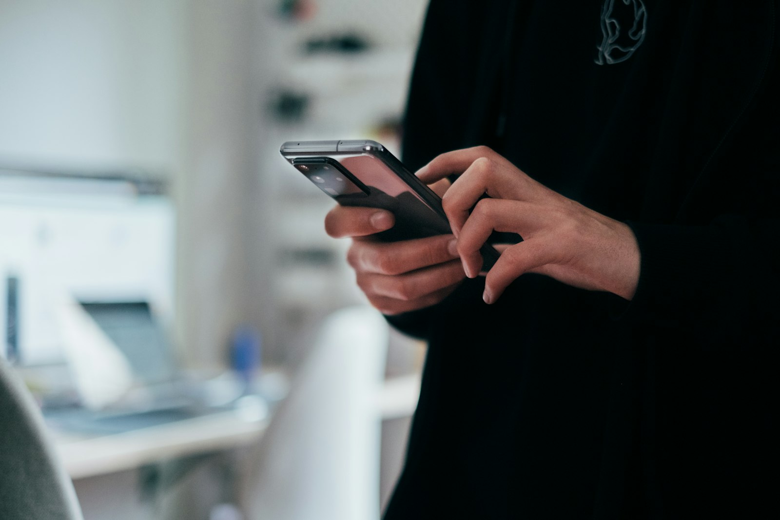 Person holding a black Android smartphone, the small screen most visitors use to browse websites