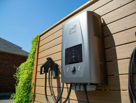 Electric car charger mounted on a wooden wall at a home